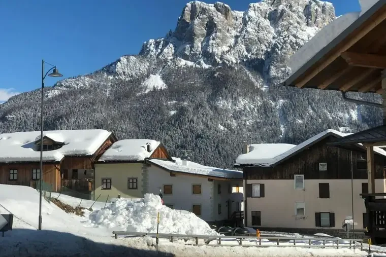 Il Catinaccio innevato sopra le case